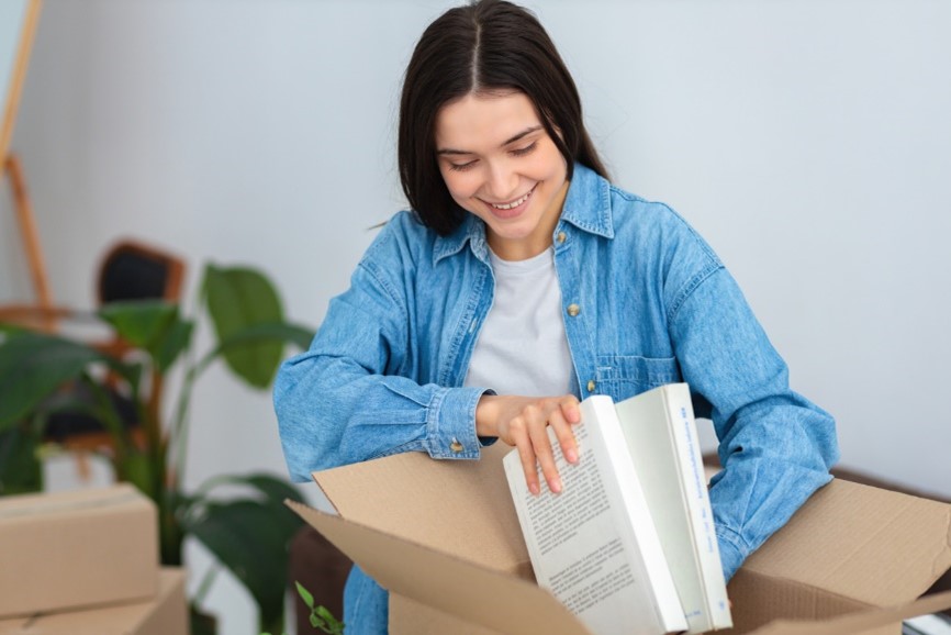 Female student packing books in a box